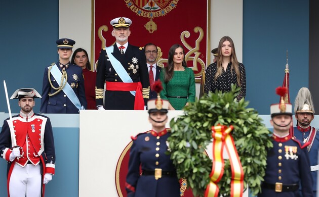 Los porta corona se desplazan a paso lento al pie de la plataforma antes de la ofrenda de la corona de laurel